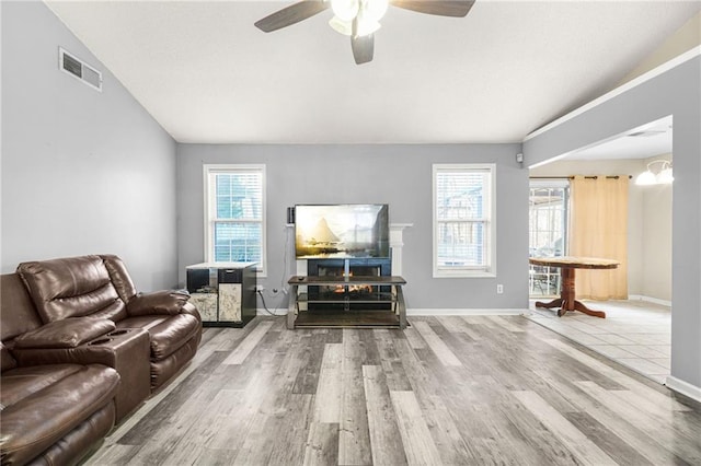 living room featuring hardwood / wood-style floors, ceiling fan, and lofted ceiling