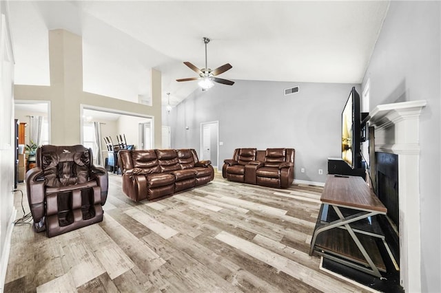 living room with ceiling fan, hardwood / wood-style floors, and high vaulted ceiling