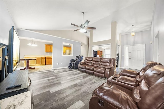 living room with high vaulted ceiling, ceiling fan with notable chandelier, and light wood-type flooring