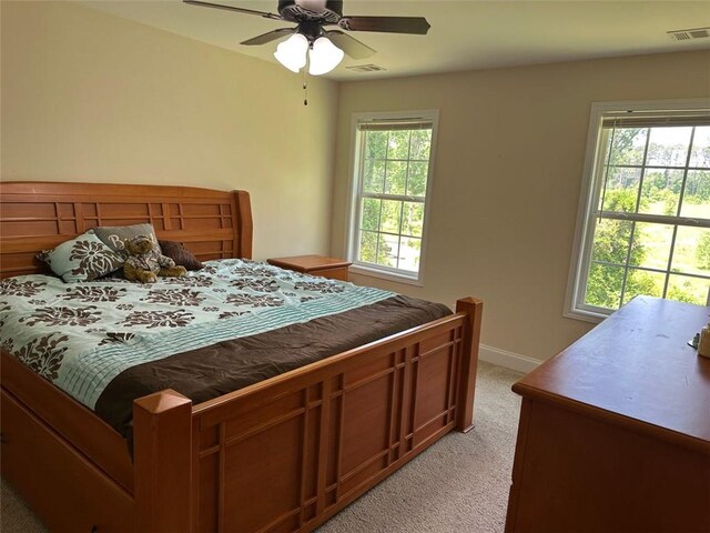bedroom featuring light colored carpet, visible vents, and multiple windows