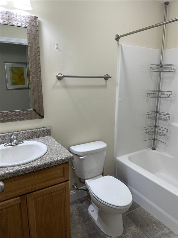bathroom with toilet, shower / washtub combination, and vanity