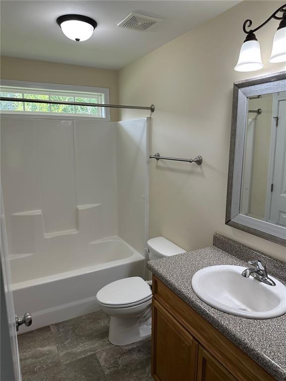 bathroom with vanity, shower / bathing tub combination, toilet, and visible vents