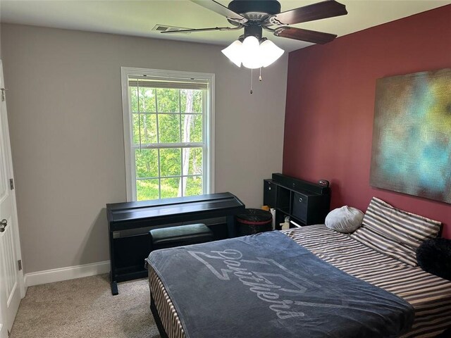 carpeted bedroom featuring visible vents, baseboards, and ceiling fan