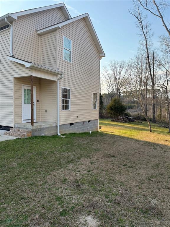 rear view of house with a yard and crawl space
