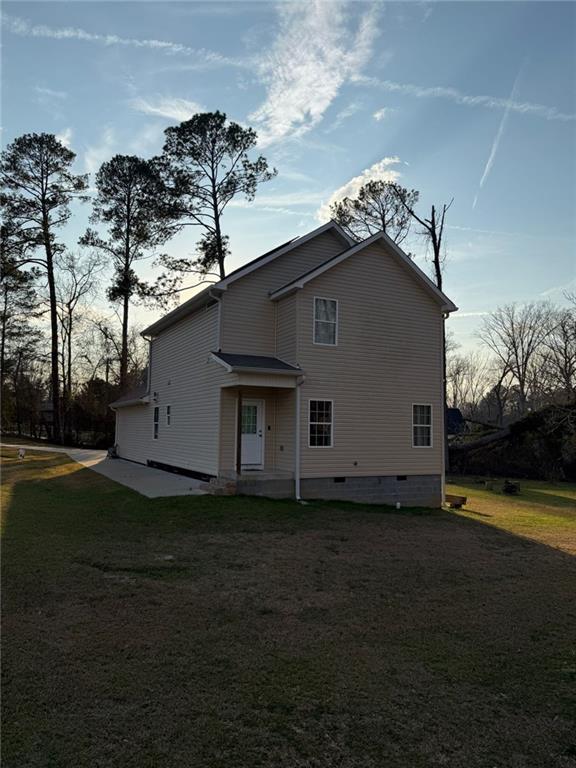 back of property with a yard and crawl space