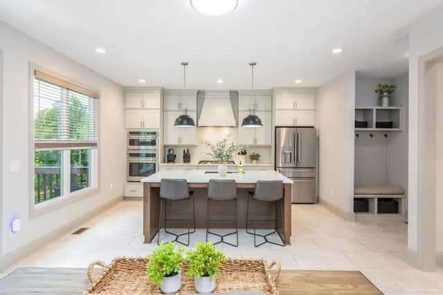 1013 Liberty Springs Dr, Woodstock, GA 30188 - kitchen with stainless steel appliances, custom range hood, light countertops, a center island, and recessed lighting