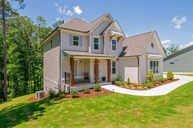 1013 Liberty Springs Dr, Woodstock, GA 30188 - view of front of property with covered porch, a front yard, board and batten siding, and roof with shingles