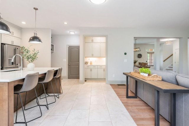 1013 Liberty Springs Dr, Woodstock, GA 30188 - kitchen featuring stainless steel fridge with ice dispenser, a sink, light countertops, recessed lighting, and a kitchen bar