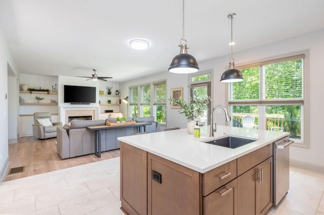 1013 Liberty Springs Dr, Woodstock, GA 30188 - kitchen with a sink, ceiling fan, a fireplace, light countertops, and stainless steel dishwasher