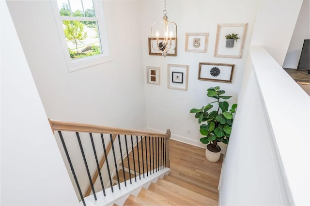 1013 Liberty Springs Dr, Woodstock, GA 30188 - stairway featuring a chandelier, wood finished floors, and baseboards
