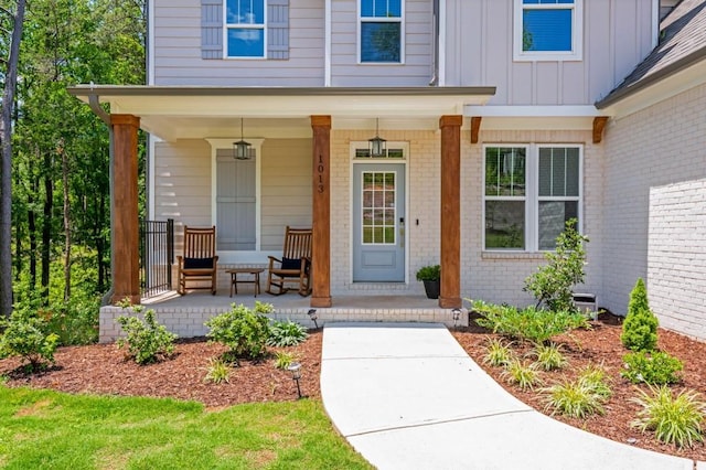 1013 Liberty Springs Dr, Woodstock, GA 30188 - view of exterior entry with covered porch, board and batten siding, and brick siding