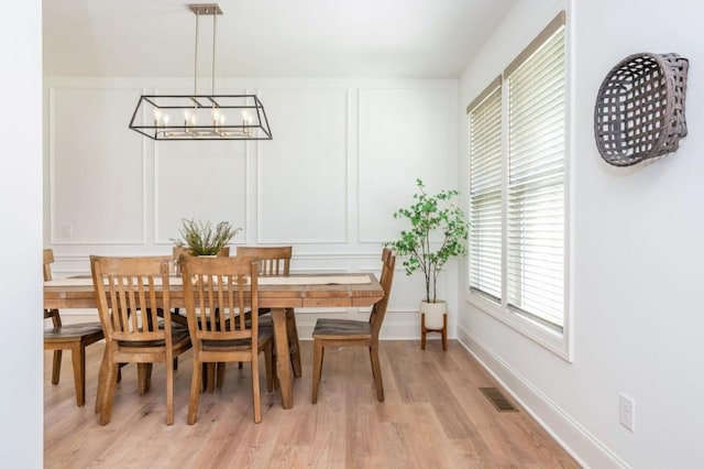 1013 Liberty Springs Dr, Woodstock, GA 30188 - dining area with a chandelier, light wood finished floors, a decorative wall, and baseboards