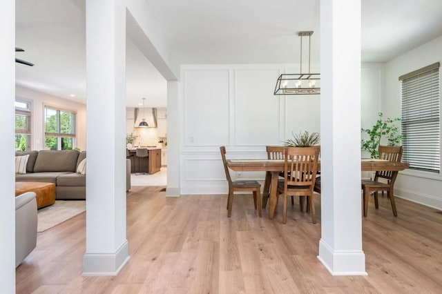 1013 Liberty Springs Dr, Woodstock, GA 30188 - dining area featuring light wood finished floors, a decorative wall, baseboards, and a chandelier