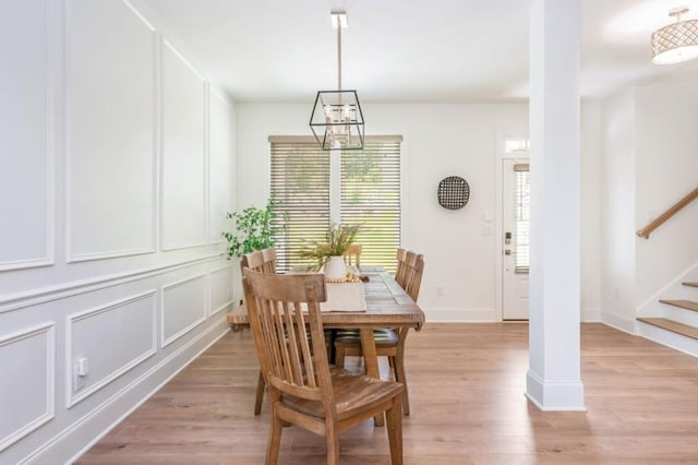 1013 Liberty Springs Dr, Woodstock, GA 30188 - dining space with healthy amount of natural light, stairway, light wood-style flooring, a decorative wall, and a chandelier