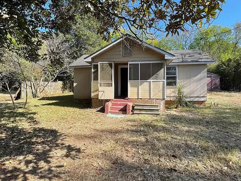 back of house with a lawn