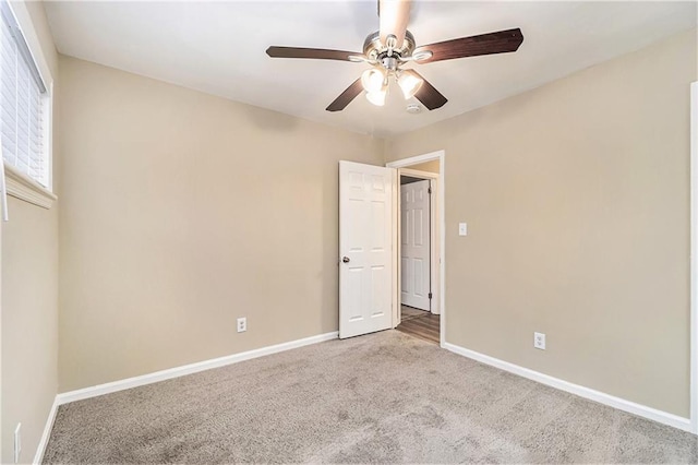 carpeted empty room featuring ceiling fan