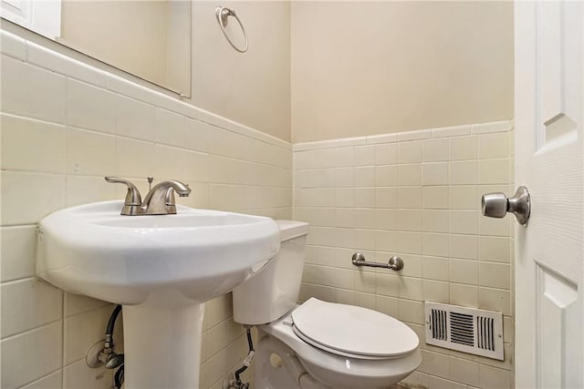 bathroom with tile walls and toilet