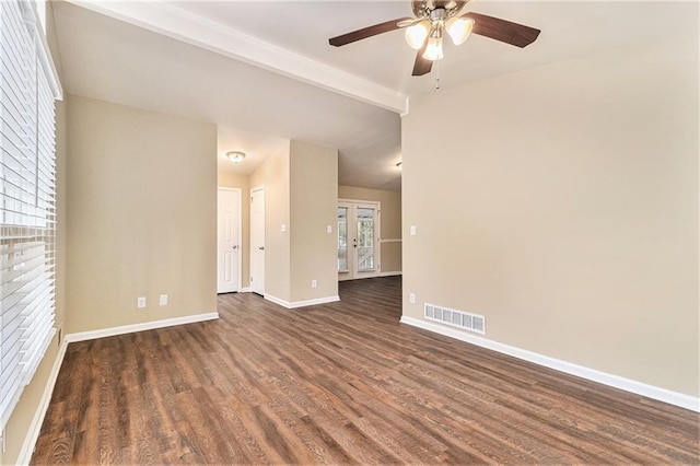 empty room with ceiling fan, dark wood-type flooring, french doors, and beamed ceiling