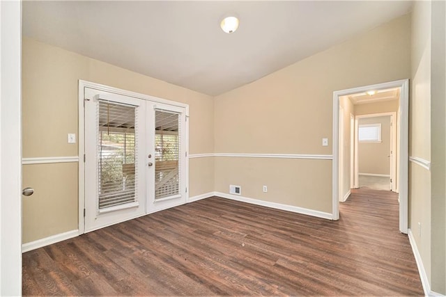 empty room featuring lofted ceiling, french doors, plenty of natural light, and dark hardwood / wood-style floors