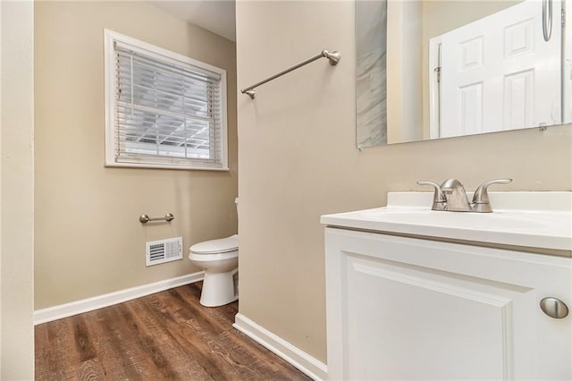 bathroom with toilet, vanity, and hardwood / wood-style flooring