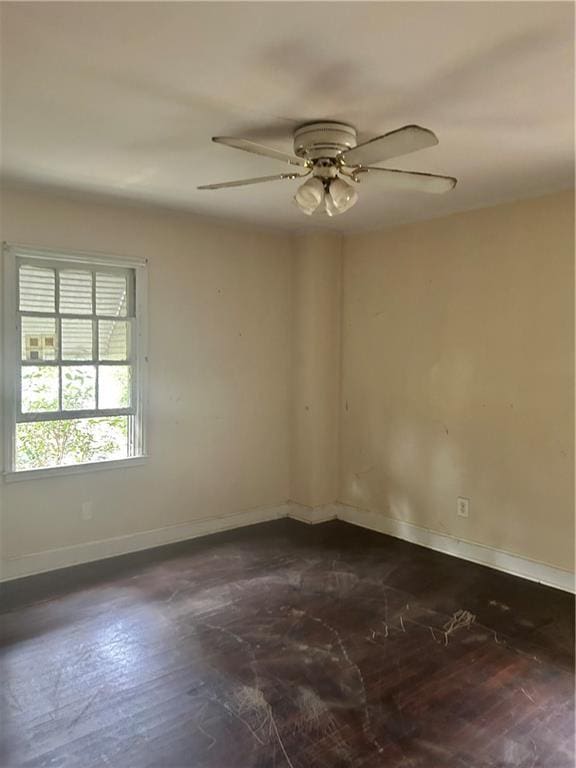 empty room featuring ceiling fan and baseboards