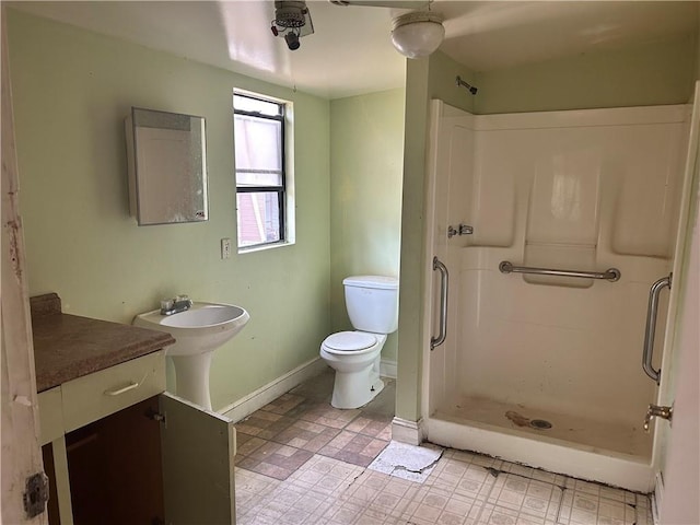 bathroom featuring a stall shower, baseboards, toilet, and tile patterned floors