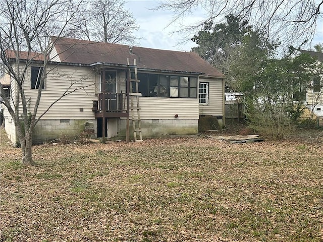 rear view of house with a shingled roof and crawl space