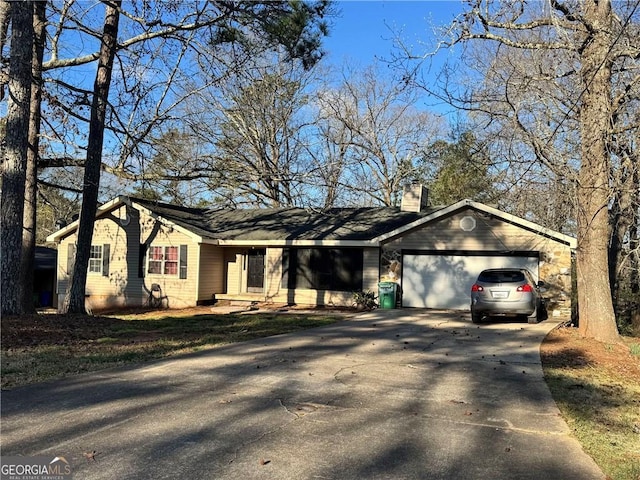 ranch-style home featuring an attached garage, driveway, and a chimney