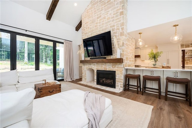 12410 Charlotte Dr, Alpharetta, GA 30004 - bedroom featuring a stone fireplace, high vaulted ceiling, wood finished floors, beam ceiling, and access to outside