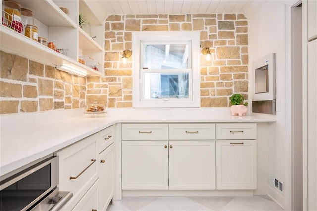 12410 Charlotte Dr, Alpharetta, GA 30004 - kitchen featuring light countertops, white cabinets, stainless steel microwave, and open shelves