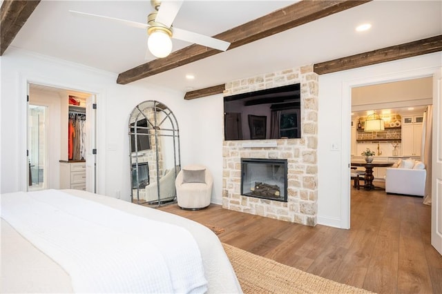 12410 Charlotte Dr, Alpharetta, GA 30004 - bedroom featuring a stone fireplace, beam ceiling, wood finished floors, recessed lighting, and ceiling fan