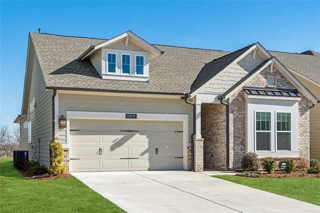 craftsman-style home with central AC unit, a garage, and a front yard