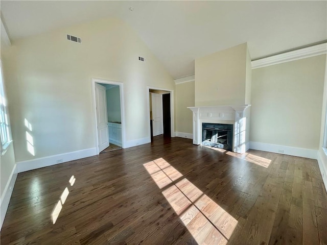 unfurnished living room with high vaulted ceiling and dark hardwood / wood-style flooring