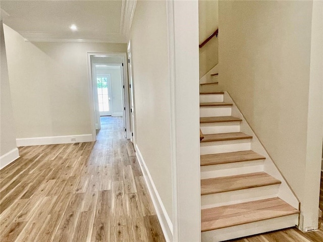 stairs with crown molding and hardwood / wood-style flooring