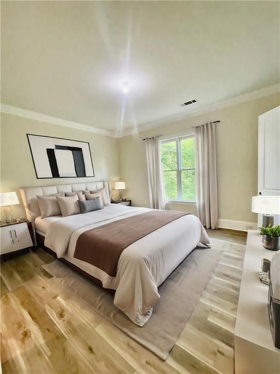 bedroom featuring light hardwood / wood-style flooring and ornamental molding