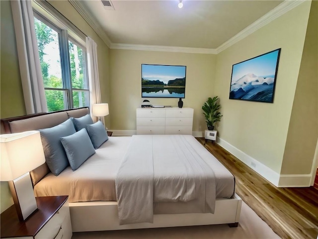 bedroom with wood-type flooring and crown molding