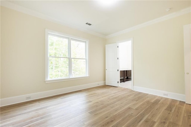 spare room with light hardwood / wood-style floors and crown molding