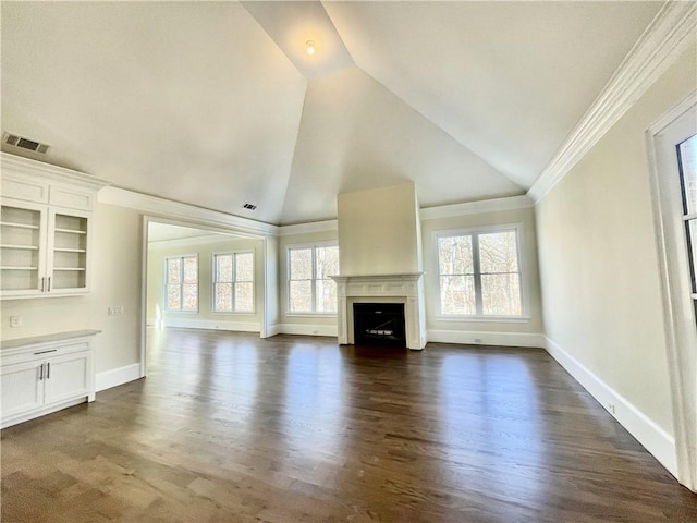 unfurnished living room featuring a wealth of natural light, lofted ceiling, and ornamental molding