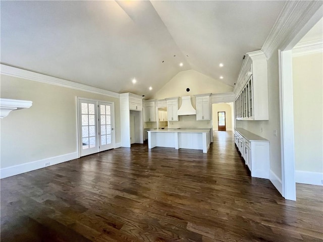 kitchen with a center island, white cabinetry, dark hardwood / wood-style flooring, premium range hood, and crown molding