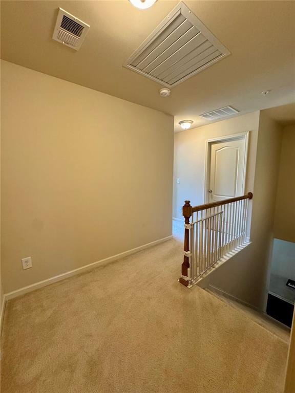 hallway featuring carpet, an upstairs landing, and visible vents