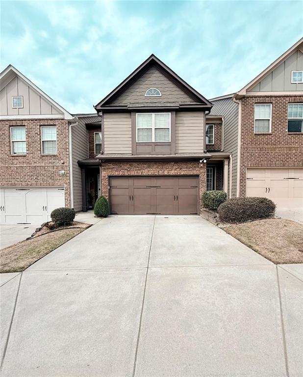 view of front facade featuring concrete driveway, brick siding, and an attached garage