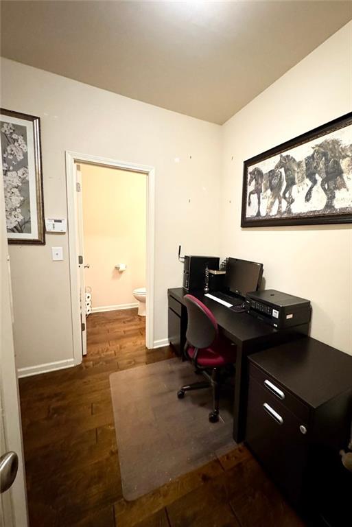 office area featuring baseboards and dark wood-type flooring