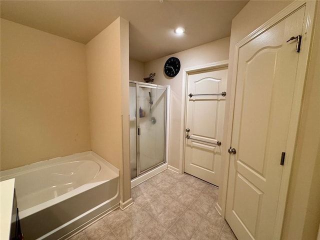 full bathroom with a shower stall, a bath, and baseboards