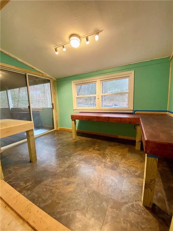 recreation room featuring lofted ceiling and baseboards