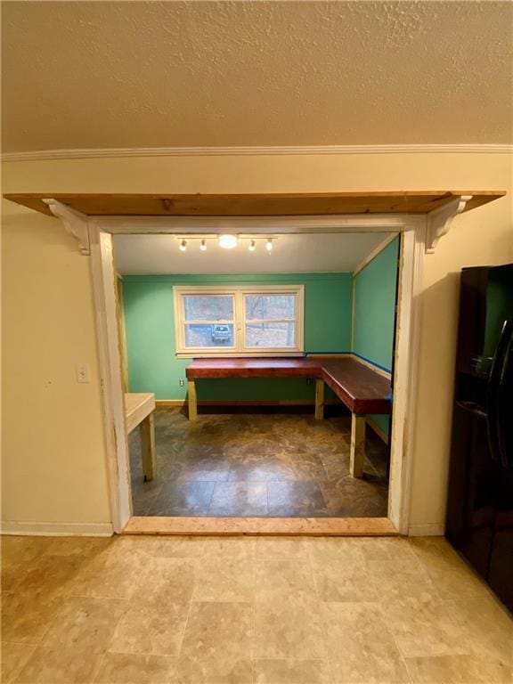 rec room featuring a textured ceiling and baseboards