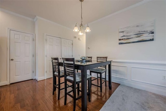 dining area featuring a notable chandelier, dark wood-type flooring, and ornamental molding