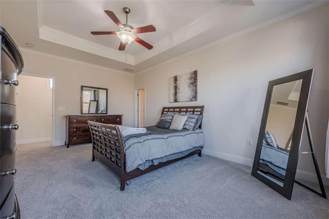 bedroom featuring crown molding, a tray ceiling, and light carpet