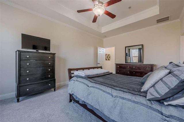 bedroom with crown molding, a tray ceiling, light colored carpet, and ceiling fan