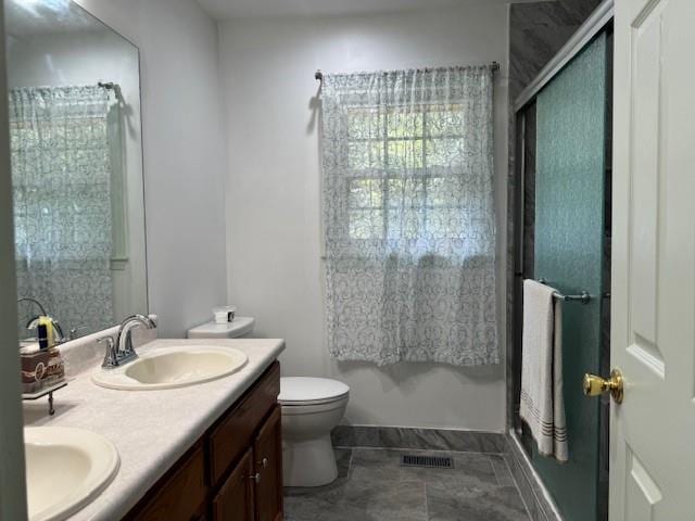 bathroom with an enclosed shower, vanity, and toilet