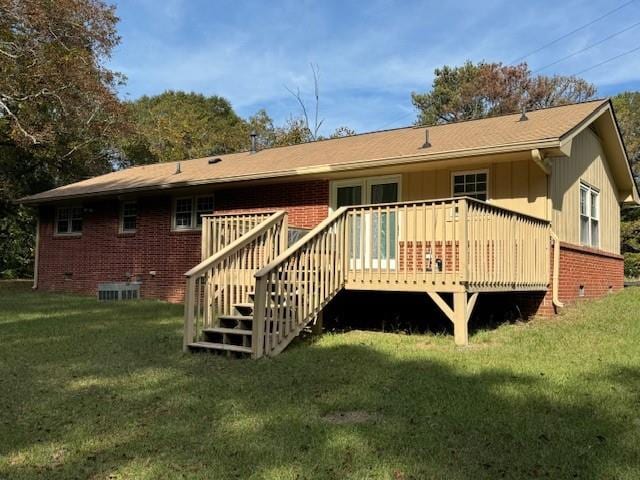 rear view of property featuring a wooden deck and a yard